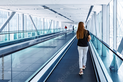 Young woman standing at the escalator in subway photo