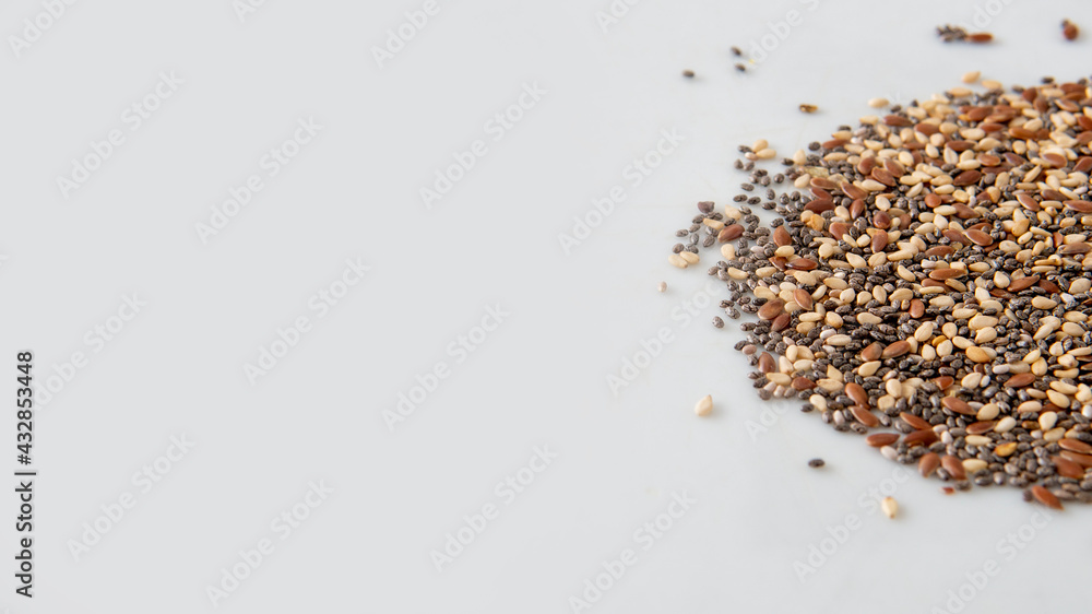 Close view of chia, flax and sesame seeds mix over a white background with copy space Close view of chia, flax and sesame seeds mix over a white background with copy space