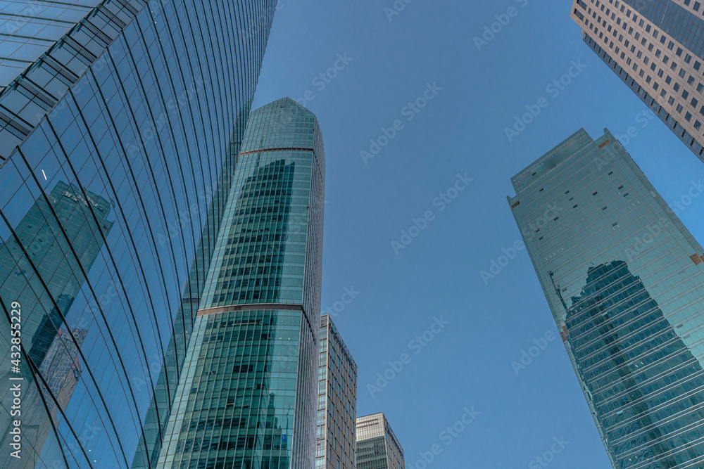 Low angle view of modern skyscraper with blue sky in Shanghai, China.