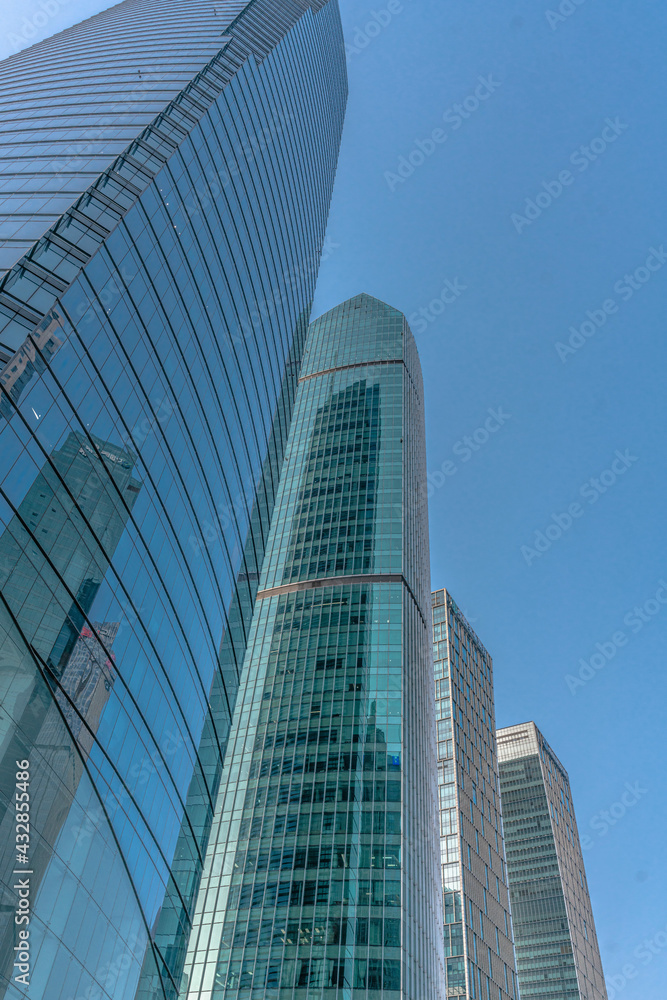 Low angle view of modern skyscraper with blue sky in Shanghai, China.