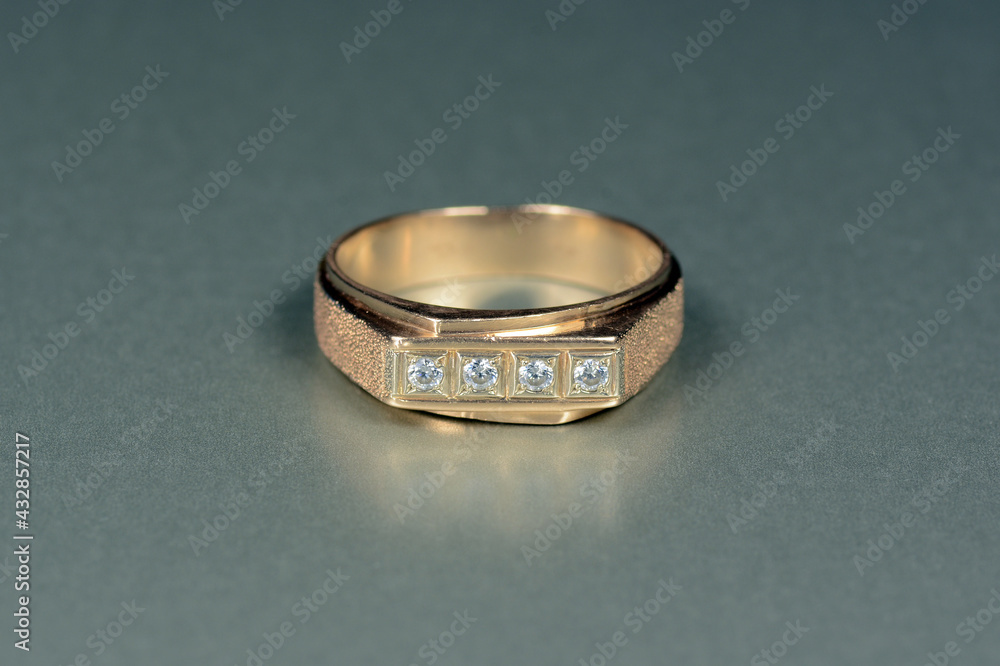 Mens, womens, unisex gold ring with CZ, cubic zirconia round white faceted  gemstones line settings, diamond imitations. Vintage, textured jewerly. Gray pattern background. Shiny blured reflection.