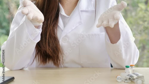 A close-up of the hands of a female doctor or nurse with medical gloves is sitting and using hands to explanation information or something.