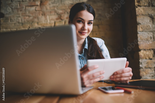 Tableau sur toile Smiling female browsing tablet during work