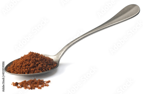 brown sugar in the metal spoon, isolated on white background