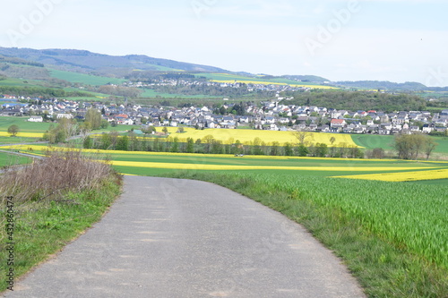 gewundene Straße in ein Eifeltal mit dem Dorf Thür photo