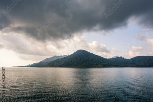 Sea and island with the rain cloud background © songdech17