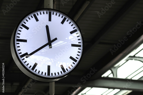 The wall clock tells the time on the station.