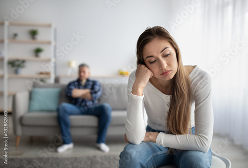 Upset mature lady having relationship problem, going through marital crisis, her husband on background, free space