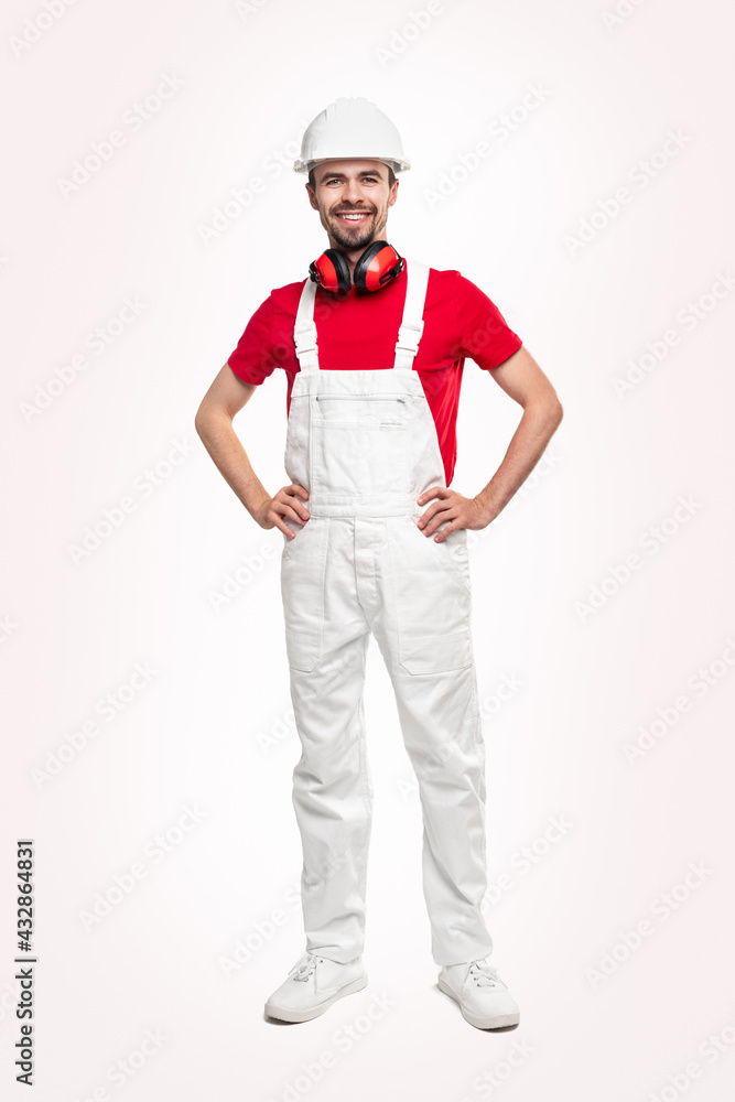 Confident builder in workwear with headphones Confident builder in workwear with headphones