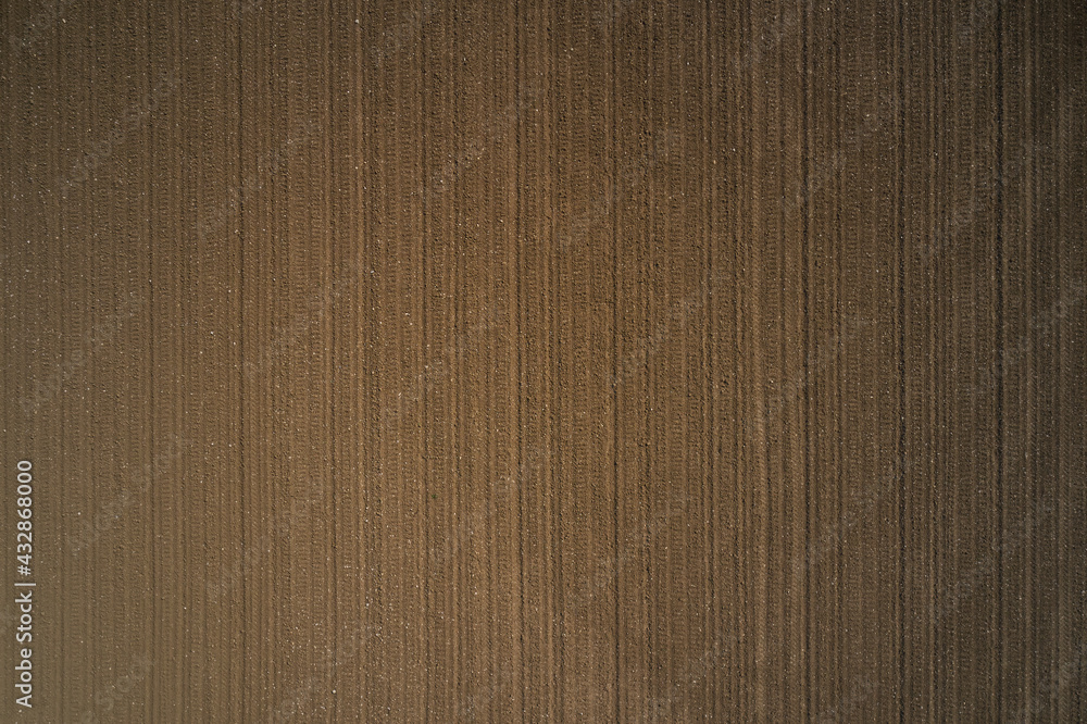 Brown ground, view to great heights. Plowed land aerial view. Cultivated soil top view. Preparing the soil for planting plants. Brown ground, view to great heights. Plowed land aerial view. Cultivated soil top view. Preparing the soil for planting plants.