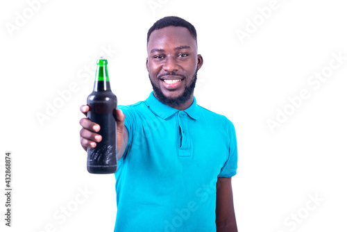 handsome happy young man offering a bottle of beer while smiling.