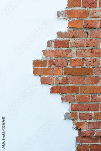 Decorative red brick masonry. Natural stone texture on a white plaster background.