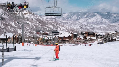 USA. Aspen. March 2021.Panoramic view on town in Colorado during winter season. People on skis and snowboards on the slopes of the ski resort. Ski elevator on snow mountain. 