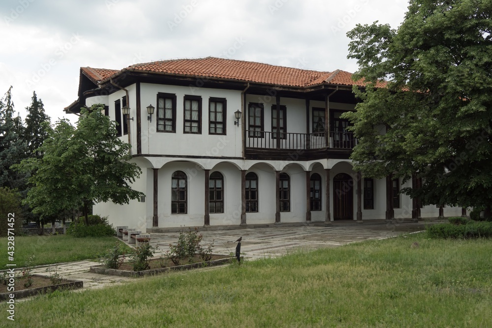 Old typical traditional Bulgarian house with white walls, wooden windows, architecture from Bulgarian National Revival period of the 19th century. Bulgaria, Kalofer. Rural view, historical tourism.