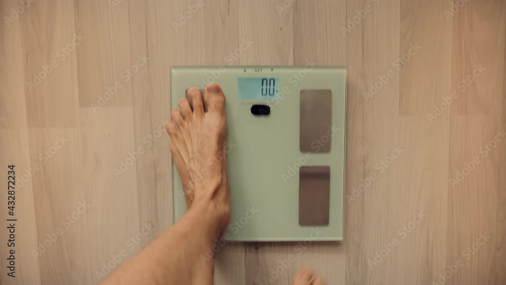 Man On Scales Measure Weight.Guy Legs Step On Bathroom Scale.Diet Man Feet Standing Weighing