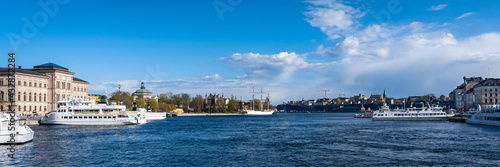 View of Stockholm, Sweden, "Skeppsholmen" island. Ship moored at embankment. Beautiful cityscape of Stockholm embankment and big sailing yacht moored. Spring sunny day. Concept of tourism and travel.