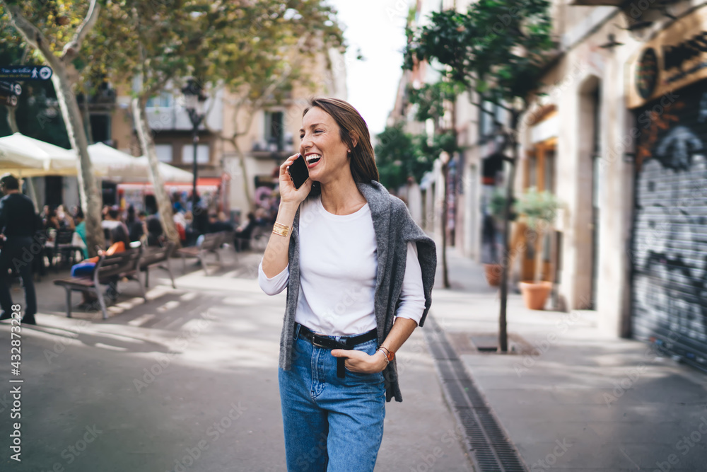 Laughing woman talking on smartphone in street Laughing woman talking on smartphone in street