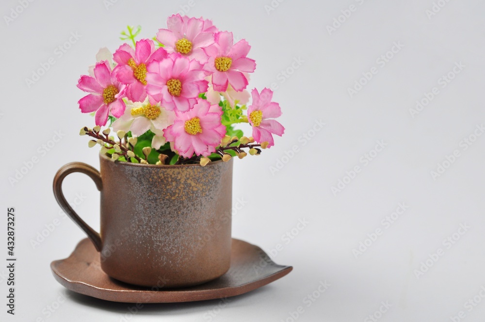 Coffee mugs or tea mugs on a bouquet of flowers isolated from a white background. Coffee mugs or tea mugs on a bouquet of flowers isolated from a white background.