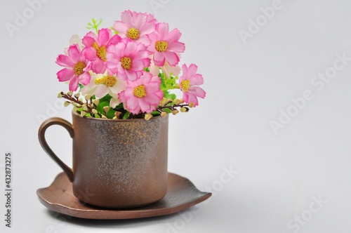 Coffee mugs or tea mugs on a bouquet of flowers isolated from a white background.