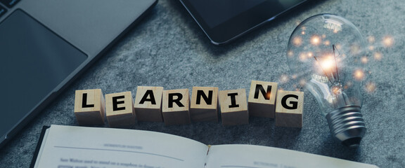 Laptop, tablet, book and glowing light bulb. Self learning or education knowledge and business studying concept. Idea of learning online class or e-learning at home.