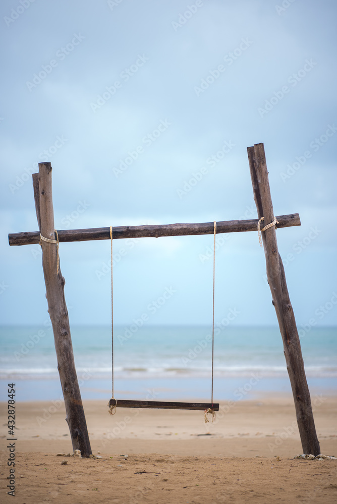 Swings on the sand tropical beach.