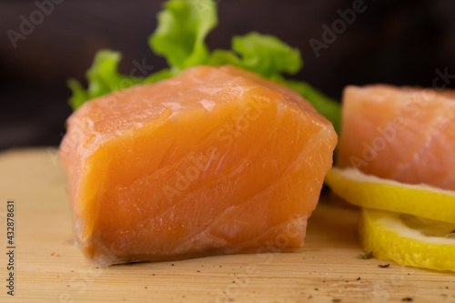 A piece of lightly salted salmon and lemon slices\ photo