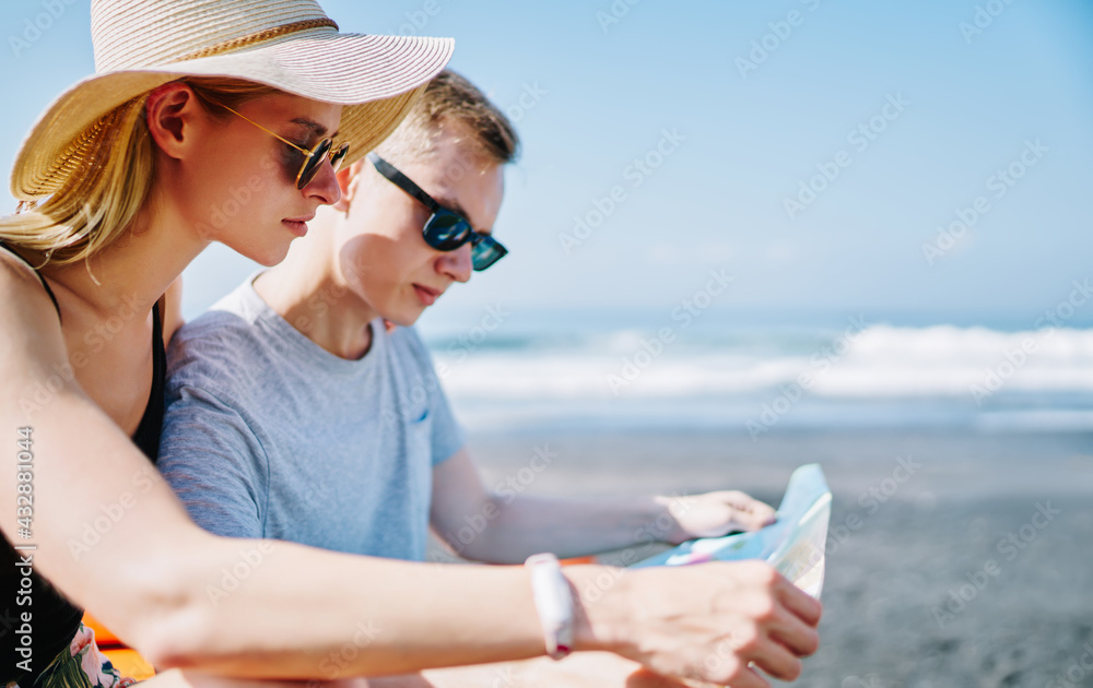 Young couple exploring map on seacoast