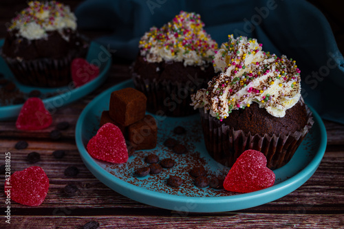 Easter morning tasty chocolate homemade muffin cupcake with white cream topin and colourful sprinkles for valentines day celebration photo