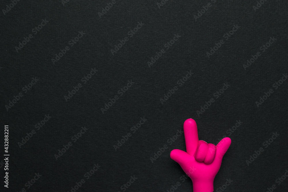 A rubber hand with folded fingers on a black background.