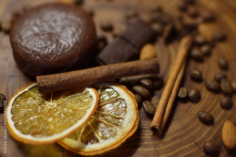 cinnamon sticks, dried orange, coffee and chocolate on a wooden surface cinnamon sticks, dried orange, coffee and chocolate on a wooden surface