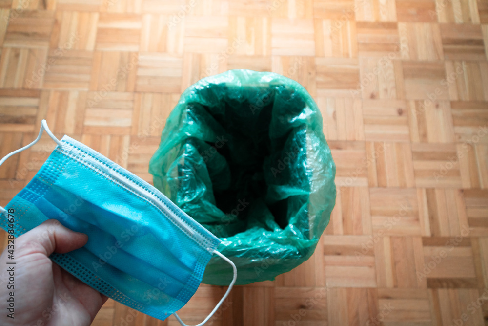 Man throwing a mask in the trash after receiving the vaccine. Concept