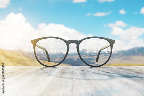 Glass lying on the surface with landscape view in the background. Perspective and travel concept, 3d rendering