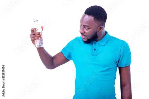 handsome young man looking at bottle of mineral water smiling.