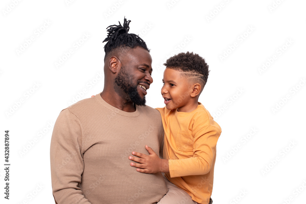 Portrait of dark skinned African male and his little son spending time together, isolated Portrait of dark skinned African male and his little son spending time together, isolated
