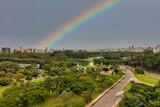 Foto aerea de São Paulo, muitas arvores e a megalopole e um lindo arco-iris ao fundo