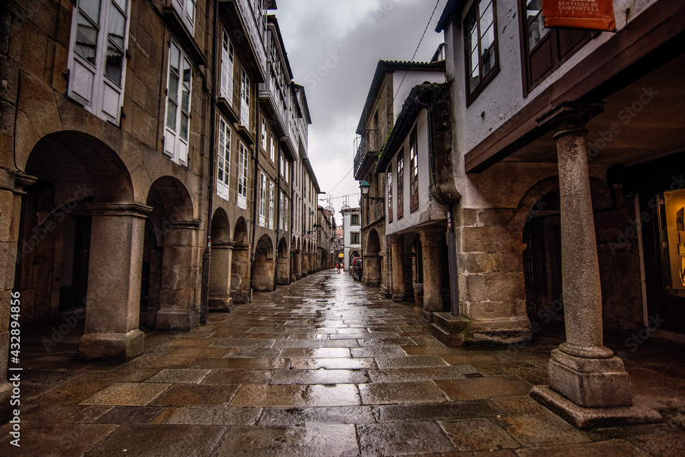 Fototapeta premium Santiago de Compostela - October 2018: Narrow street with porticoes in Santiago de Compostela on a rainy day