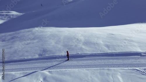 Person  cross country skiing on a slope through wild snowy mountain wilderness on a clear cold winters day.