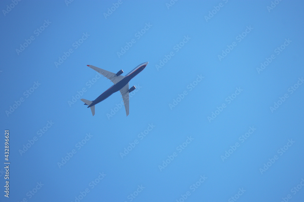 Airplane flying on clear blue sky background. Passenger plane is gaining altitude Airplane flying on clear blue sky background. Passenger plane is gaining altitude