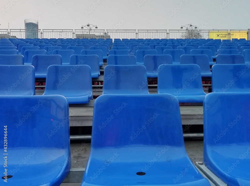 Naklejka premium Seats at the stadium. shallow depth of field. Empty blue seats in a row at the sport stadium. 