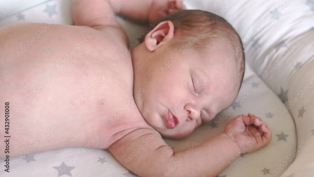 Close-up portrait of a sleeping newborn baby. Child croaks in a dream, crying. Newborn health. Infancy, childhood, and health concept. Face of newborn naked calm. Baby grimaces lying on back. Close-up portrait of a sleeping newborn baby. Child croaks in a dream, crying. Newborn health. Infancy, childhood, and health concept. Face of newborn naked calm. Baby grimaces lying on back.