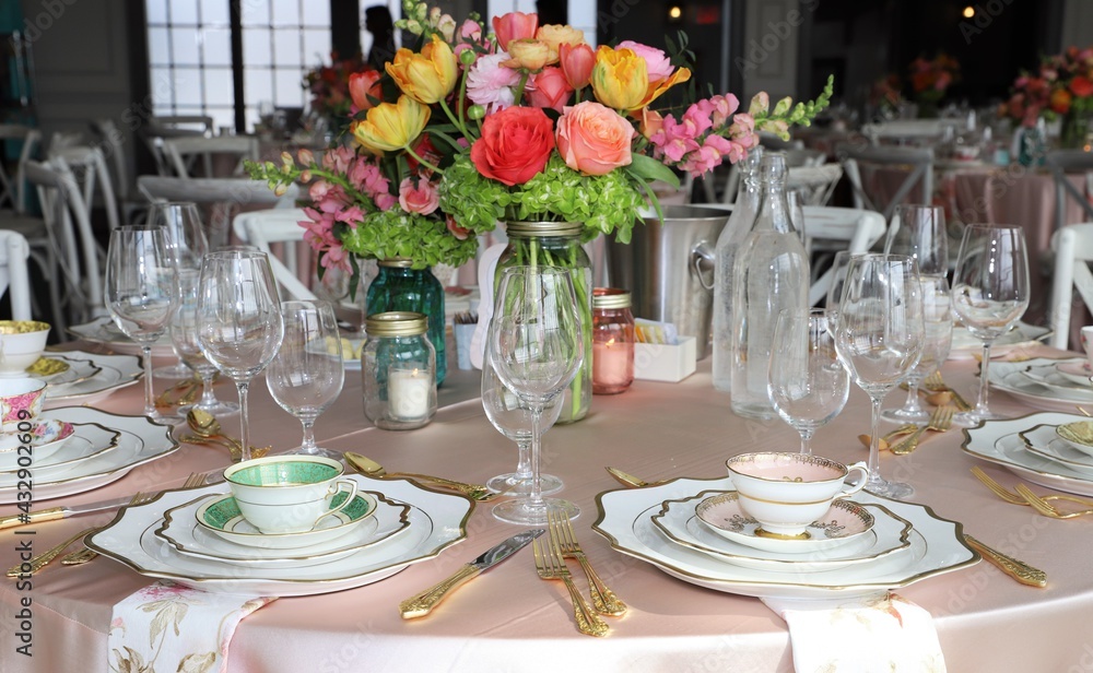 Table set up for bridal shower on bright spring day with flowers in the middle and vintage tea cups on each plate Table set up for bridal shower on bright spring day with flowers in the middle and vintage tea cups on each plate