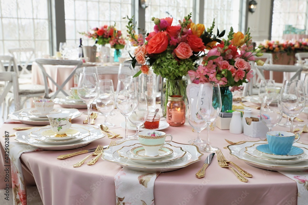 Table set up for bridal shower on bright spring day with flowers in the middle and vintage tea cups on each plate Table set up for bridal shower on bright spring day with flowers in the middle and vintage tea cups on each plate