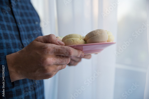 the hands of a man in a blue shirt are holding macaroons