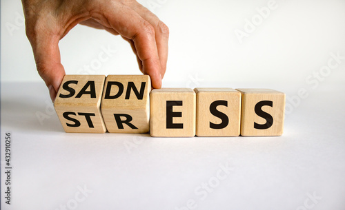 Sadness and stress symbol. Doctor turns cubes and changes the word 'stress' to 'sadness'. Beautiful white table, white background. Medical, psychological and sadness to stress concept. Copy space. photo