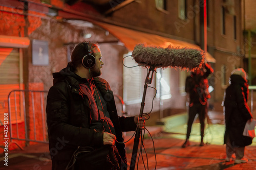 Sound engineer with a microphone on the set. A professional sound engineer at work on the filming of a movie