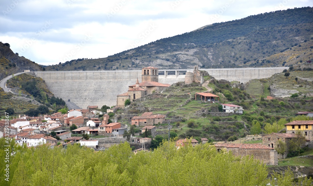 Enciso town with the dam on top. Houses of the town, its church and castle, behind the concrete wall.
