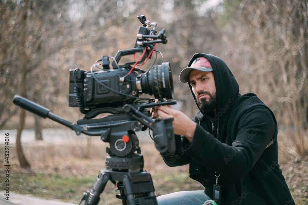 Director of photography with a camera in his hands on the set. Professional videographer at work on filming a movie Director of photography with a camera in his hands on the set. Professional videographer at work on filming a movie