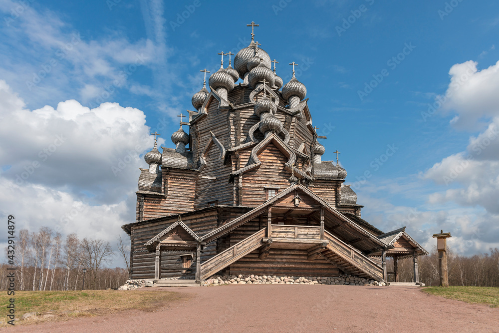 Old historic wooden church in the suburbs of the Russian city of St. Petersburg against the background of a blue cloudy sky Old historic wooden church in the suburbs of the Russian city of St. Petersburg against the background of a blue cloudy sky