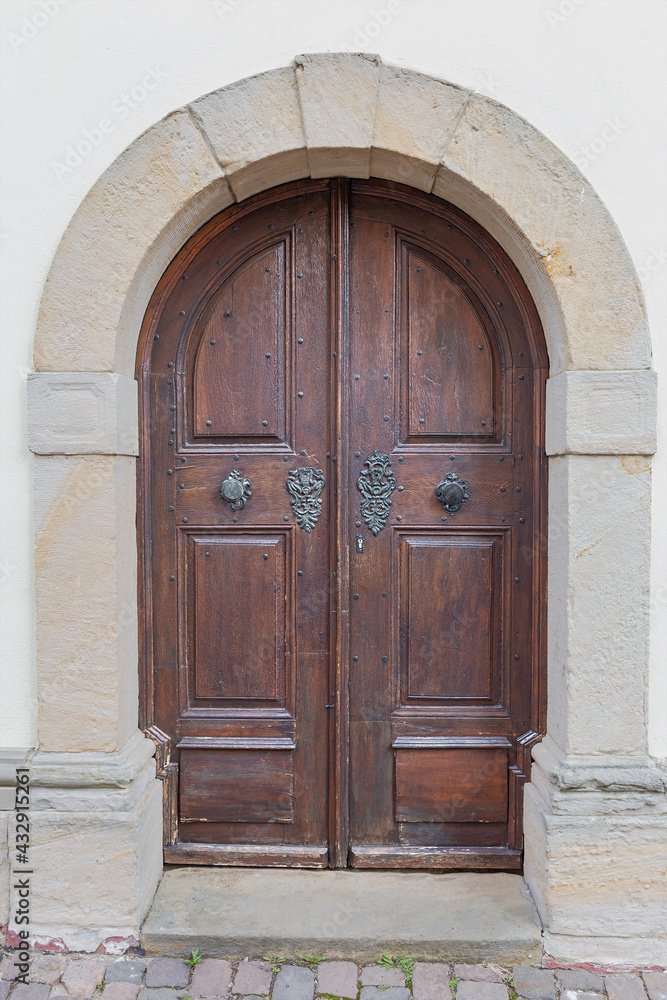 old wooden door, finished with metal decorations in the historic part of the German town of Mainz
