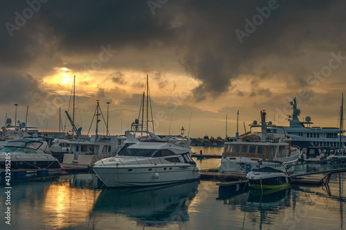 White yachts and boats in the sea harbor of the Russian resort on the Black Sea against the backdrop of a beautiful sunset sky